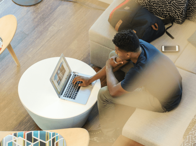 A young man looking a laptop